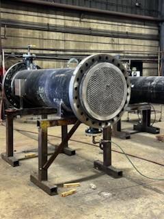 Fabricated pipe spool with flanged end staged in shop for NDT inspection and documentation.